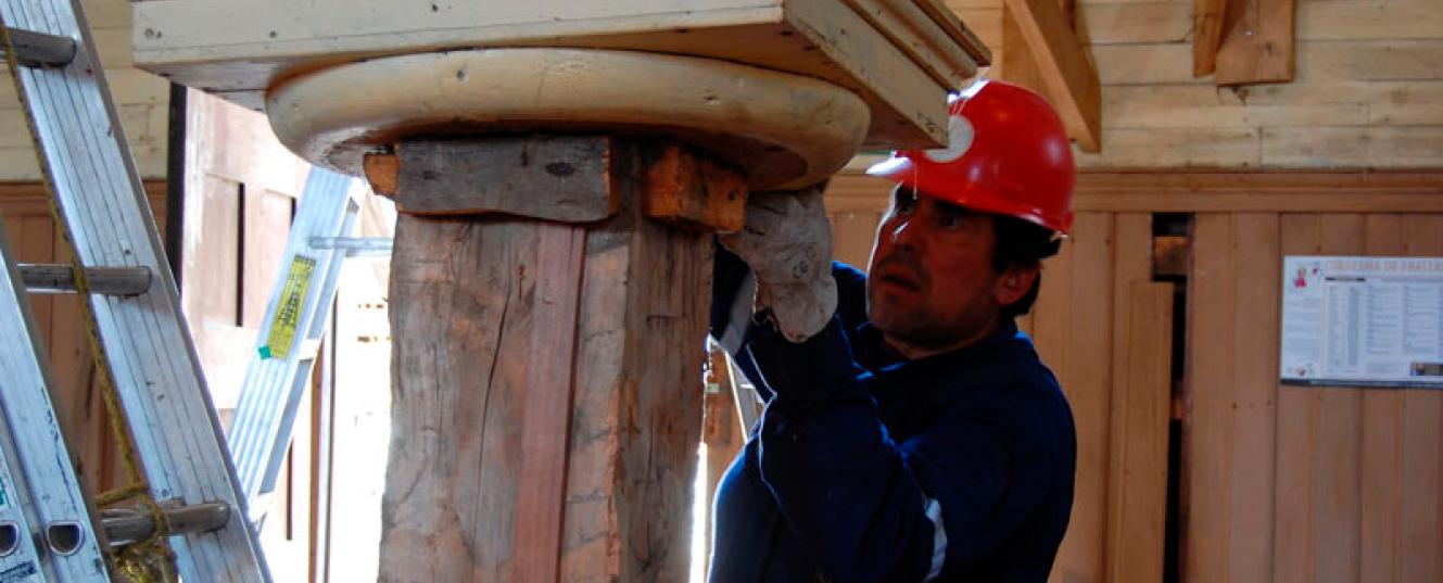 un hombre remodelando estructura de iglesia un pilar